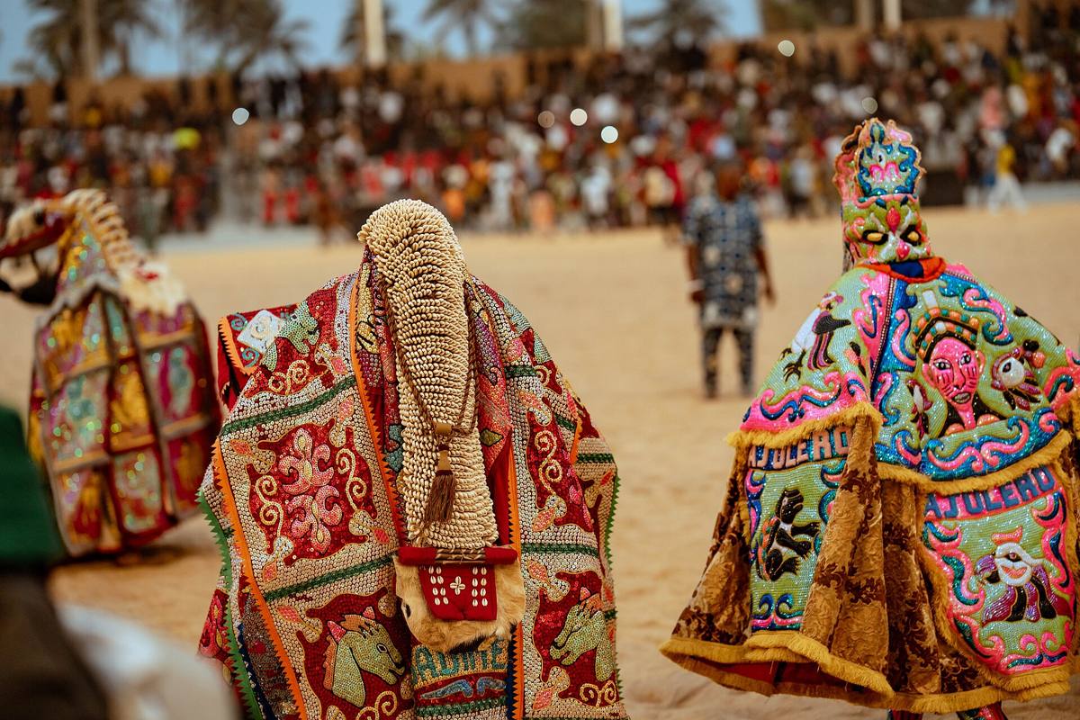 Masques Egoungoun en costumes brodés lors d'une cérémonie à Ouidah